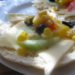Chlebek pita z serem, ogórkiem, kukurydzą, papryką i oliwkami